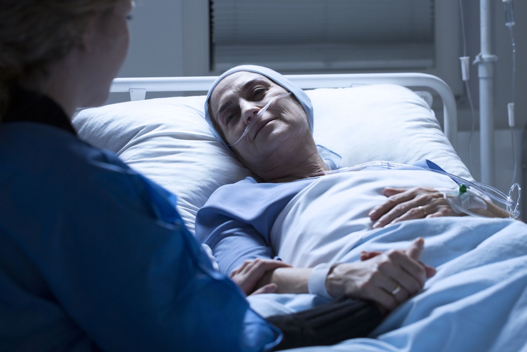 Palliativpatientin erhält Sauerstoffsonde und Zuspruch im Bett