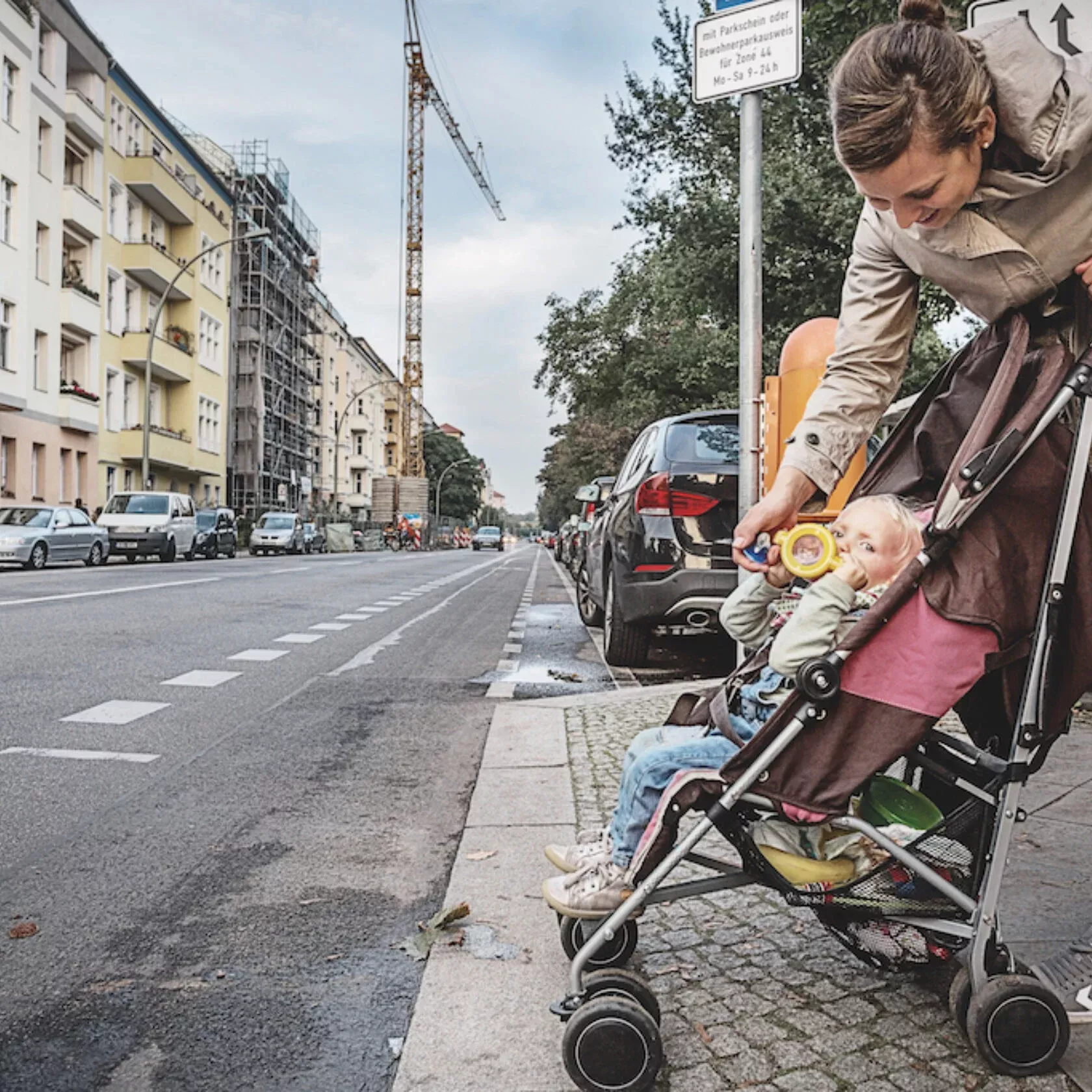 Frau gibt Kleinkind vor der Straße das Fläschchen